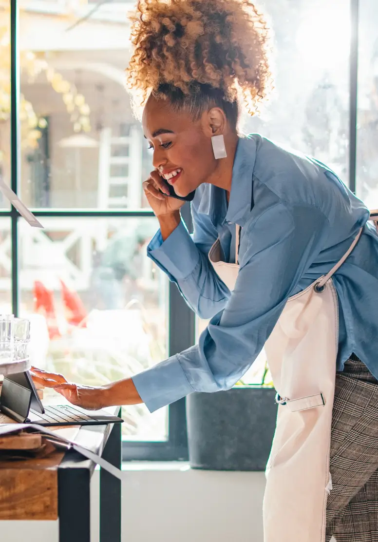 Business Owner with apron working on computer